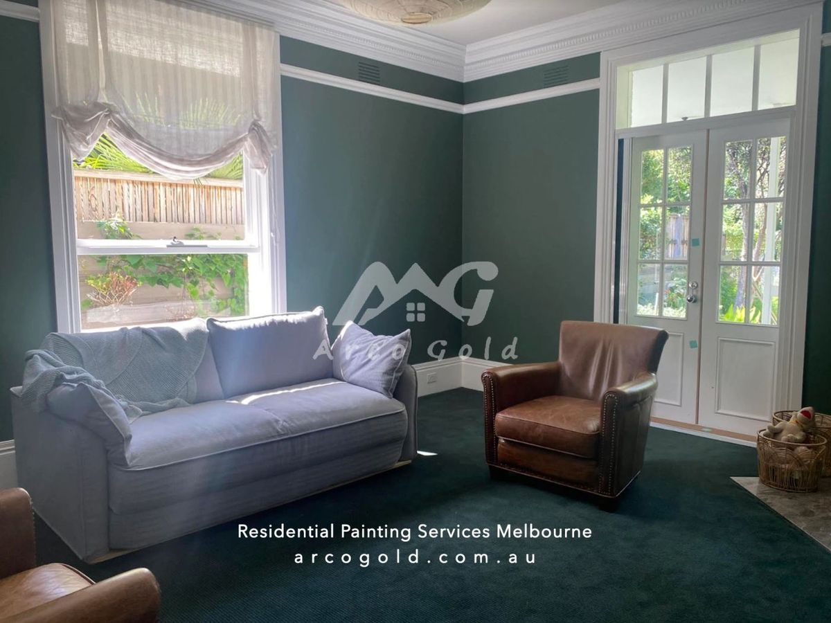 Living room finished in deep green with white trim