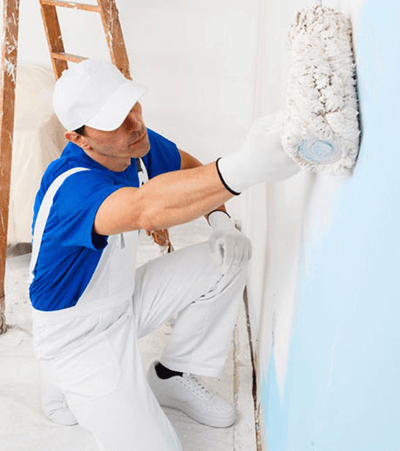 Painter applying a coating along a wall