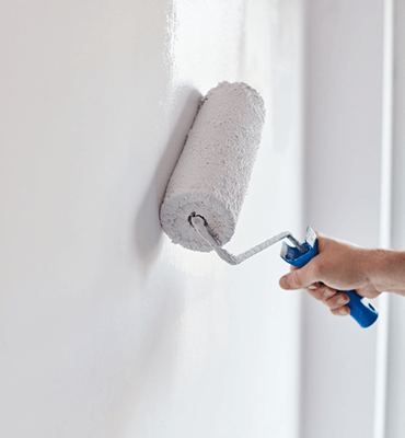 Roller finishing a smooth white wall